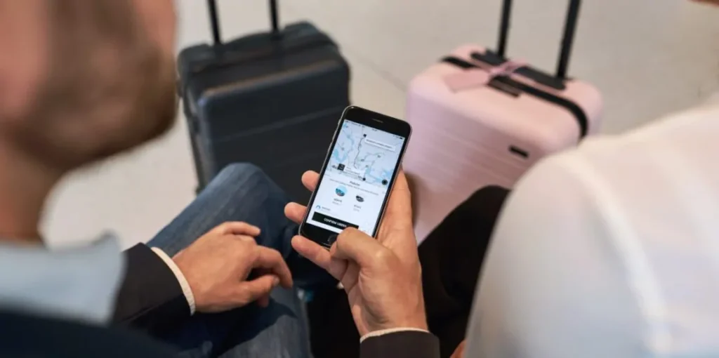 People waiting with luggage, using phone
